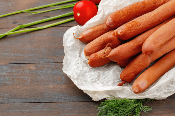 新鲜的肉香肠放在棕色的木桌上图片下载