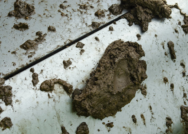 一辆旧车门上的泥。一个金属特写上的污垢和灰尘的纹理。水滴和飞溅在银色的背景上。图片下载