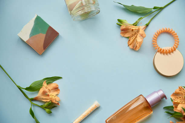 美平躺着，中间有拷贝空间。橙色瓶身，紫花，斑块。女性化的概念。化妆品会让人崩溃图片下载