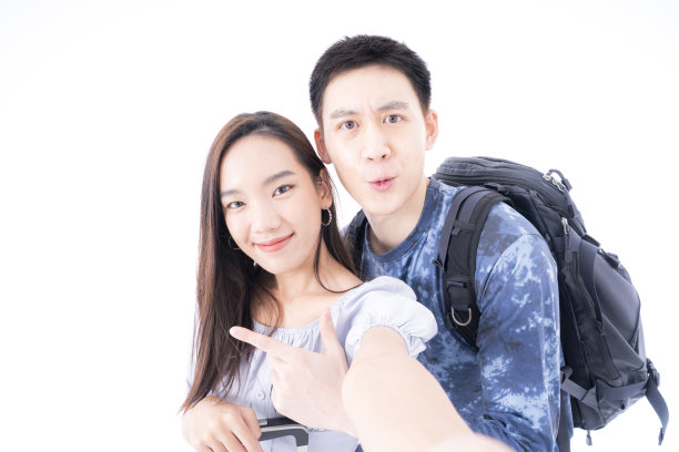 年轻夫妇视频通话和去国外度假。年轻夫妇自拍快乐，并去旅行。亚裔女性和男性以白人背景旅行。图片下载