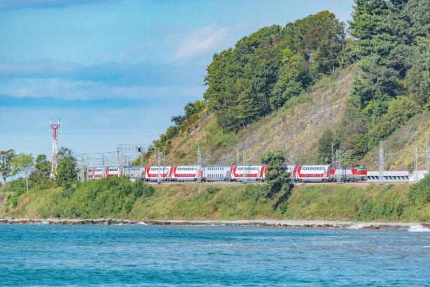 一列双层客运列车沿着黑海海岸行驶。索契。图片下载
