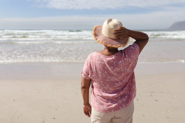 后视图的非洲裔美国妇女站在海滩上图片下载