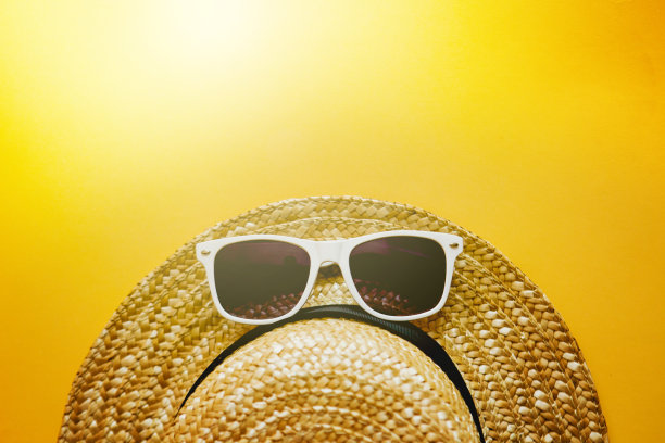 黄色背景的太阳镜和草帽。文本。图片下载