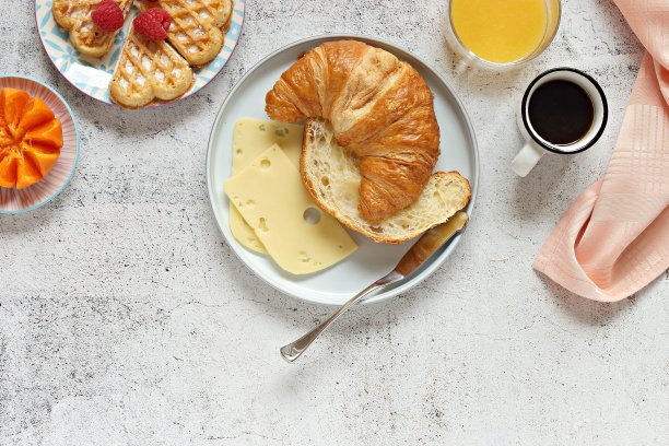 牛角面包三明治与熏鲑鱼，奶酪，黄瓜和微型绿色蔬菜。图片下载