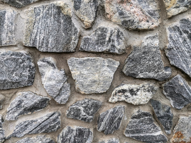 在柔和的灯光下，旧的灰色纹理砖石栅栏图片下载