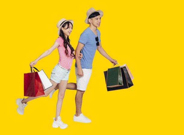 侧面的年轻夫妇走和拿着购物袋图片下载