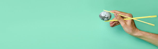 一个年轻人手里拿着一个太空蛋，霓虹灯背景是日本筷子。最小的复活节假期或食物概念。蛋画的抽象概念图片下载