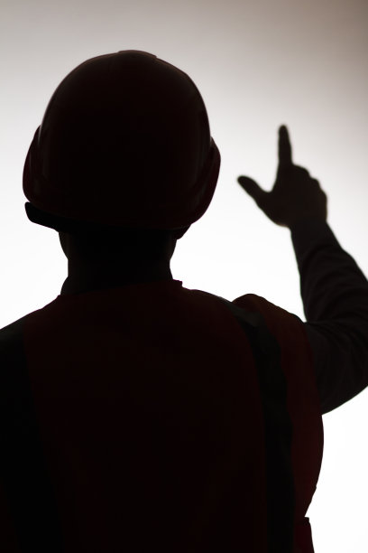 在孤立的背景上，年轻建筑工人的剪影与手向前，目标概念图片下载