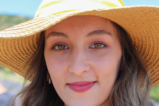 微笑的美丽女子与草帽，浅黑色，彩色的眼睛图片下载