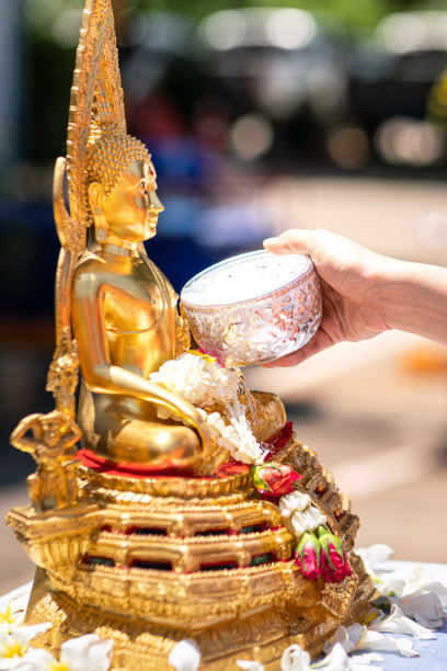 泼水节-向金佛雕像浇水的动作。图片下载