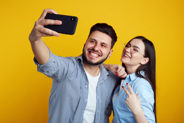 一名男子和一名女子在工作室里自拍，在黄色背景下被隔离图片下载