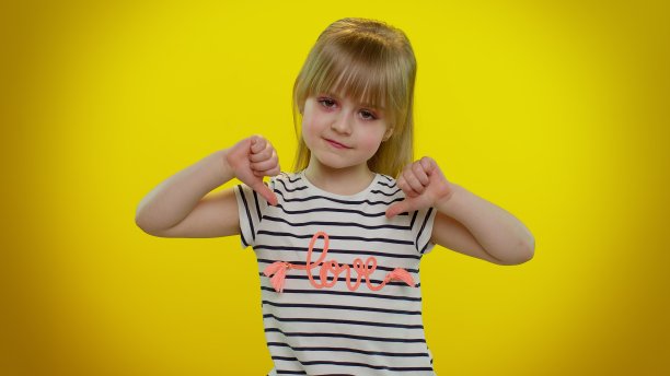 心烦意乱的小女孩用拇指向下的手势表示不满，不赞成，不喜欢图片下载