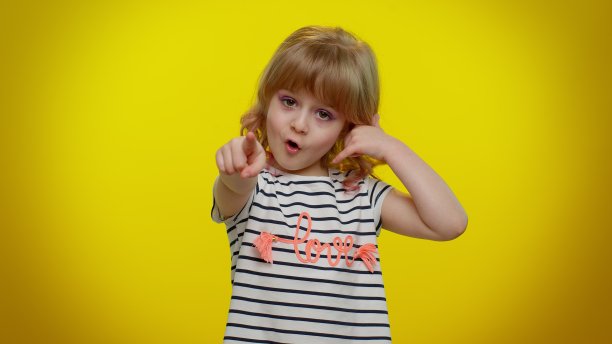 可爱的金发小女孩看着镜头做着手机手势，好像在说嘿，你给我回电话图片下载