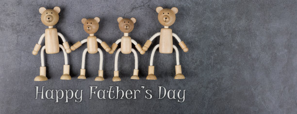 祝您父亲节快乐。贺卡与家庭木制玩具熊在黑暗的背景。横幅。图片下载