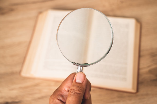放大镜对翻开的旧书，研究的概念，搜寻和阅读。图片下载
