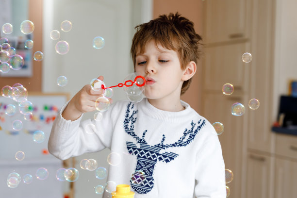 快乐的小男孩在家里玩肥皂泡。孩子的乐趣。孩子们在学校玩耍，做实验图片下载