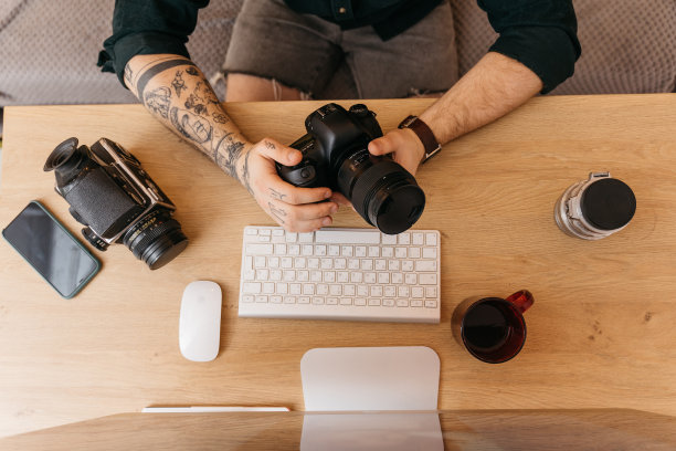 在自己的摄影棚拍摄前，一名男子在检查他的相机设置图片下载