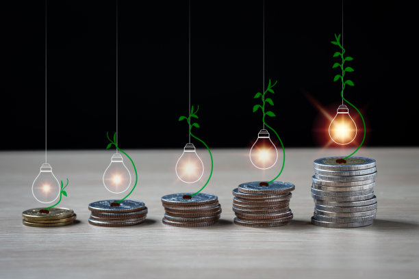 金银硬币是灵活的五叠。它们上面有明亮的灯泡，从硬币到灯的顶部有一个藤蔓，按上升顺序储蓄的概念。图片下载