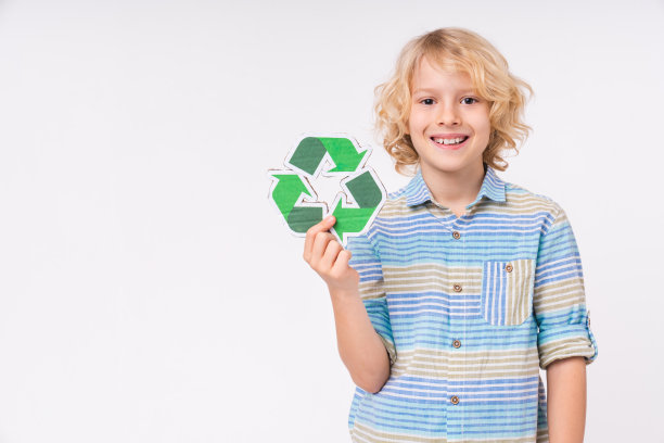 开朗的白人少年拿着回收标志孤立的白色背景图片下载