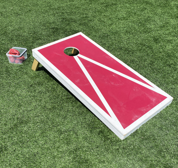 红色和白色的玉米洞游戏板与豆袋被扔图片下载