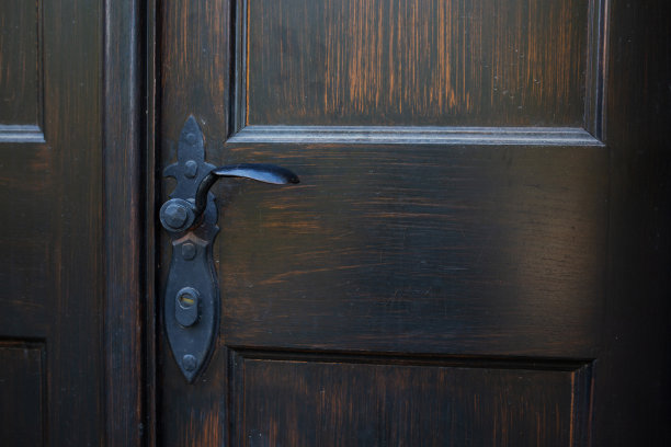 外面一扇油漆木门上锻造手柄的特写图片下载