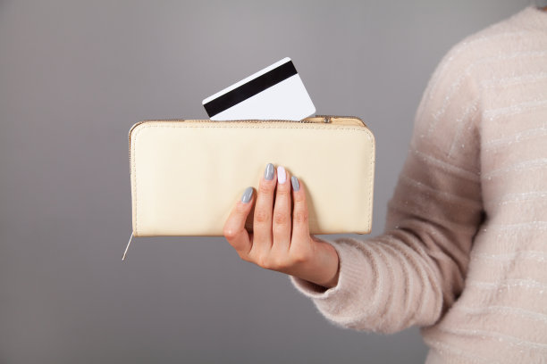 女人把一张信用卡放在钱包里。图片下载