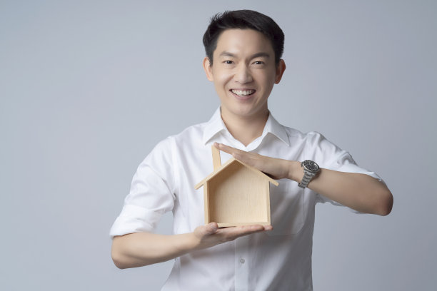 商业保险沟通理念概念与亚洲迷人的男性休闲t恤手握木屋模型盒微笑和幸福的手势姿势呈现点显示快乐的时刻图片下载