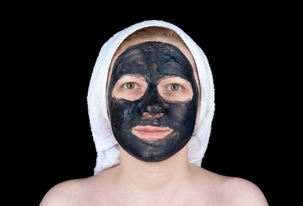 一名年轻女子用活性炭面膜擦洗脸部。图片下载