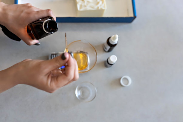 一位做肥皂的妇女在厨房秤上称做化妆品用的芳香油。家庭spa。小型企业图片下载