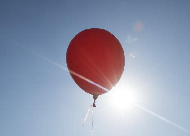 红色气球和蓝天背景与太阳图片下载