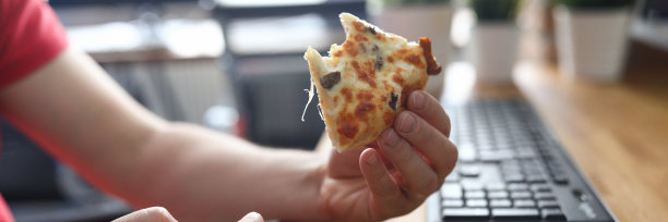 男人的手臂拿着一大块硬皮的新鲜披萨图片下载