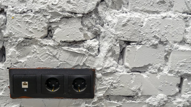 白色砖墙，黑色插座。空间的文本。图片下载