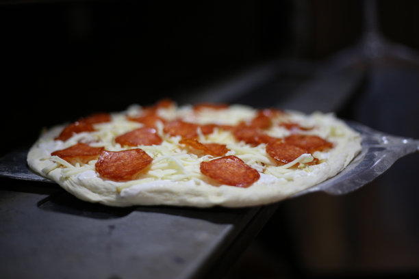 把披萨放进烤箱的照片图片下载