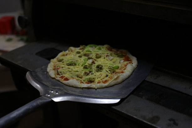 把披萨放进烤箱的照片图片下载