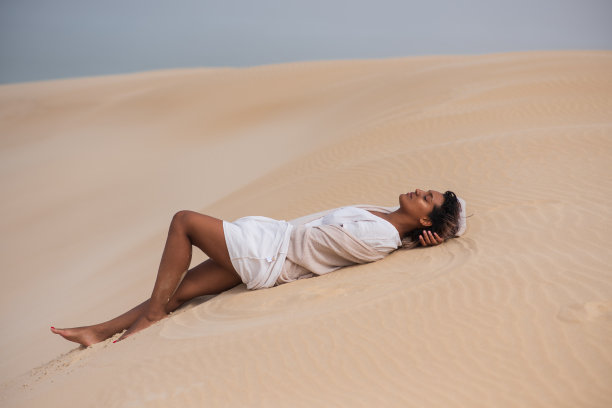 女人躺在沙丘上的风景照片图片下载