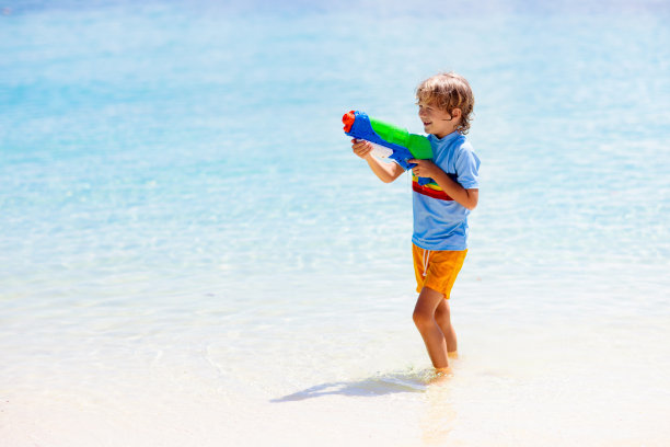 孩子拿着玩具水枪。孩子们度假海滩的乐趣。图片下载