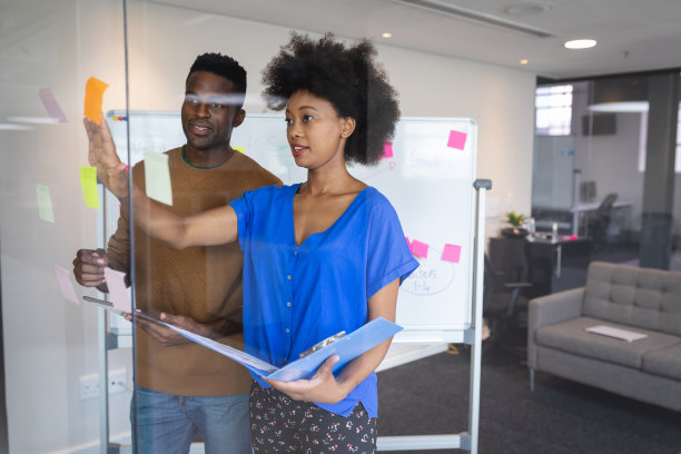 不同的男女同事站在白板前讨论图片下载