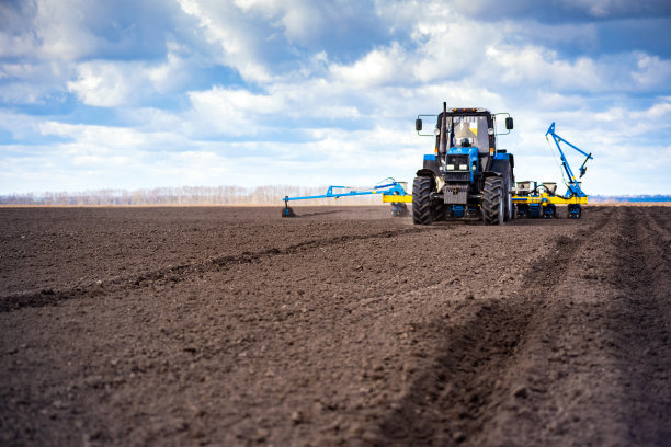 春天在田间播种。拖拉机和播种机图片下载