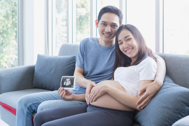 妈妈和爸爸抱着宝宝的超声波照片。妈妈和爸爸正在展示他们胎儿的超声波图像。心形的手。新出生的。图片下载