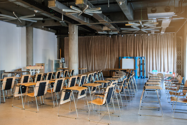 培训室/会议厅内部的视图，有一排排的木椅和一张小桌子图片下载