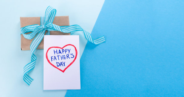 快乐的父亲节。蓝色的小背景，给爸爸一个礼物盒和一张卡片，上面写着:父亲节快乐图片下载