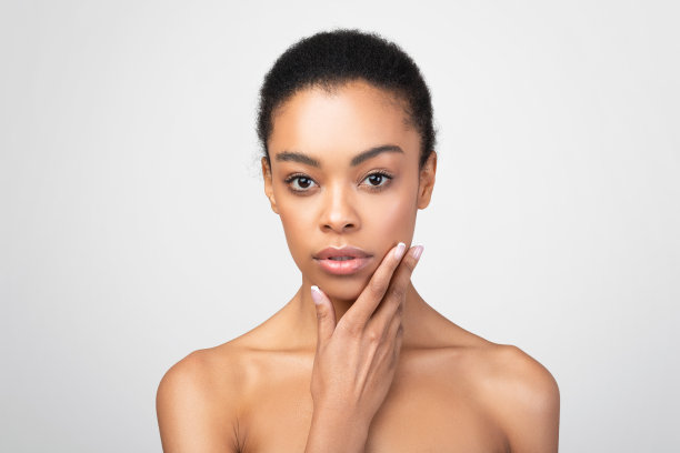 感性的非洲裔美国女人触摸下巴摆姿势赤膊，灰色背景图片下载