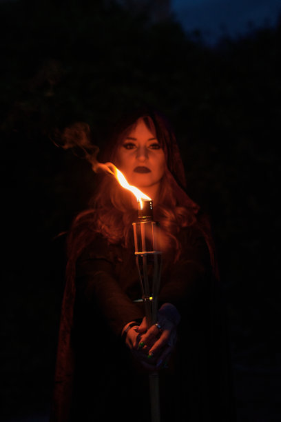 装扮成女巫的女人拿着熊熊的火炬图片下载