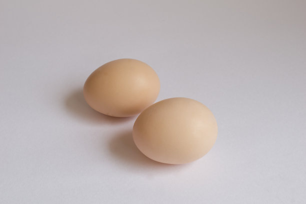 两个淡黄色的鸡蛋在孤立的白色背景上的图片。图片下载