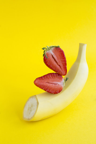 切好的香蕉和草莓放在黄色的背景上图片下载
