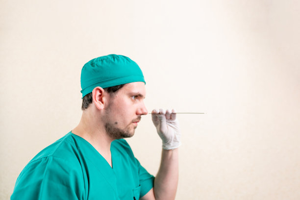 耳鼻喉科医生，戴着口罩和眼镜，手里拿着一个设备。图片下载