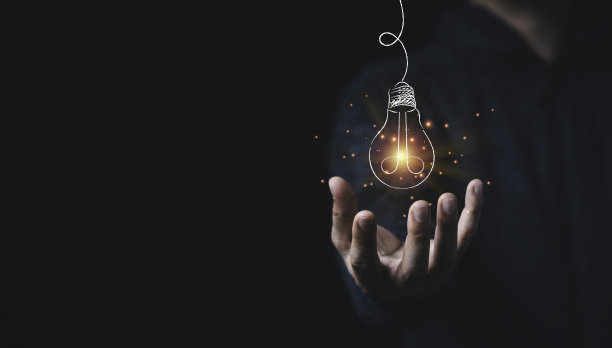 男人手牵着挂着发光的画着橙色光芒的灯泡，创意思维的想法和创新的理念。图片下载
