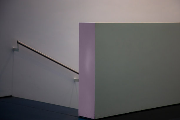 一个灰色和紫色的墙壁元素在楼梯前面引导下，一个金属扶手的墙壁在柔和的灰色复制空间图片下载