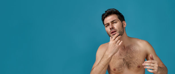 有吸引力的自信的棕色头发的人与完美的皮肤水疗后摆出孤立的蓝色背景图片下载