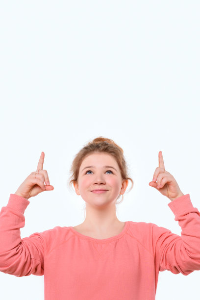 迷人的年轻女孩手指向上，展示好的购物网站，推荐点击链接。放置文本的位置图片下载